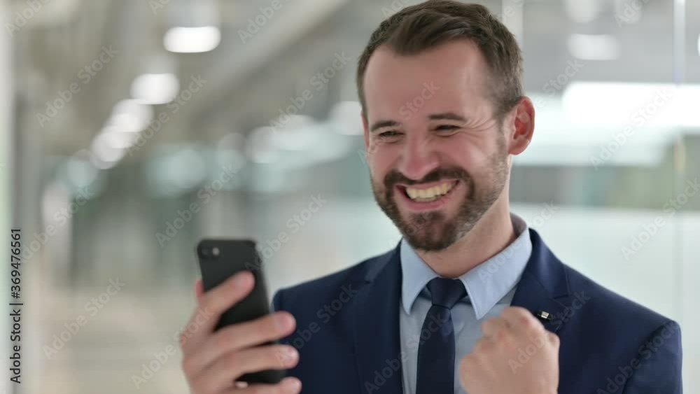 Portrait of Businessman Celebrating Success on Smartphone Portrait of Businessman Celebrating Success on Smartphone