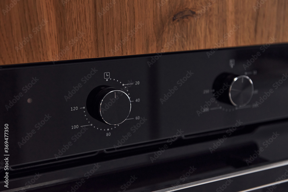 Fototapeta premium Close up view of gas stove knobs indoors in the kitchen. Wooden material