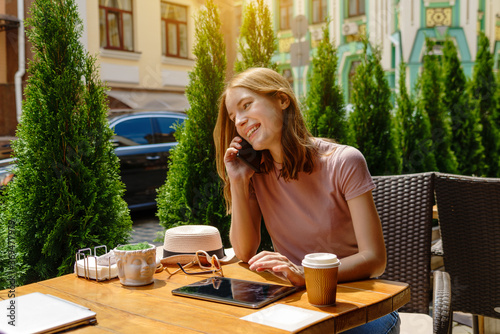 young woman using tablet pc in a cafe on a summer terrace