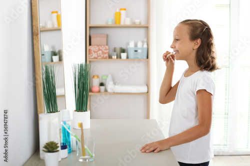 Little girl brushes her teeth in the bathroom. Dental care for children
