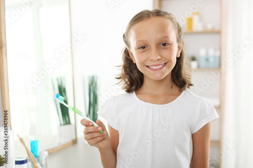 Little girl brushes her teeth in the bathroom. Dental care for children 
