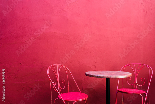 Pink street cafe table with chairs on pink wall