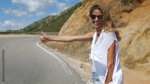 Wallpaper Mural An young happy smiling tourist woman is hitchhiking a ride from car in amazing landscape nature during summer holidays vacation trip. Torontodigital.ca