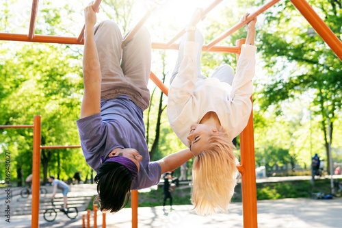 Happy teen couple having fun on playground in a city park