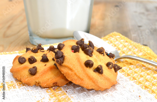 Freshly baked chocolate chip cookies in plate on clothtable photo