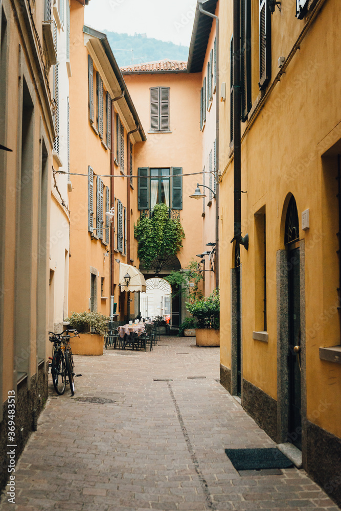 Fototapeta premium Como city - old small town in Italy - empty street with street cafe