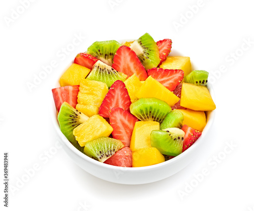 Fruit fresh salad in bowl, diet concept. Healthy salad of mixed fruits strawberry, kiwi, mango, pineapple isolated on white. Dieting health vitamin meal