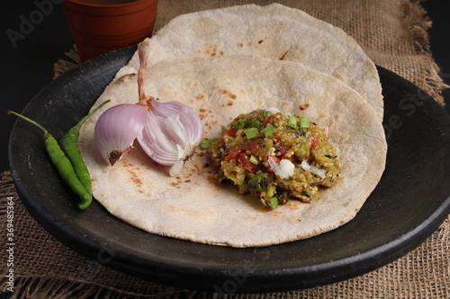 Baigan/Baingan Bharta - Mashed roasted Eggplant cooked with spices & vegetables. Served with Jowar flour flat bread known as bhakar/bhakri. Served on earthen plate. served on earthen plate. photo