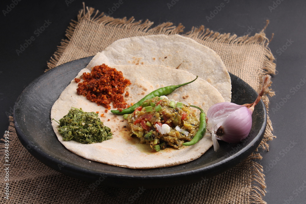 Baigan/Baingan Bharta Mashed roasted Eggplant cooked with spices & vegetables, crushed gree
