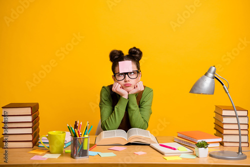 Portrait of her she attractive bored indifferent girl nerd geek learning grammar sticker note on forehead homework project isolated bright vivid shine vibrant yellow color background photo