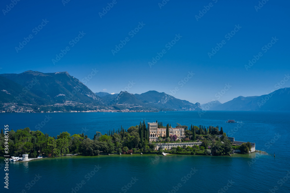 Aerial view of the island Garda, Lake Garda, Italy Aerial photography.  In the background Alps, blue sky