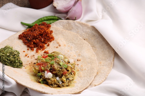 Baigan/Baingan Bharta - Mashed roasted Eggplant cooked with spices & vegetables, crushed gree chillis - thecha and garlic chutney. Served with Jowar flour flat bread known as bhakar/bhakri. photo