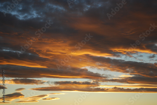 Dramatic sky clouds. Orange lenticular clouds. Sunset. South Patagonian sky.