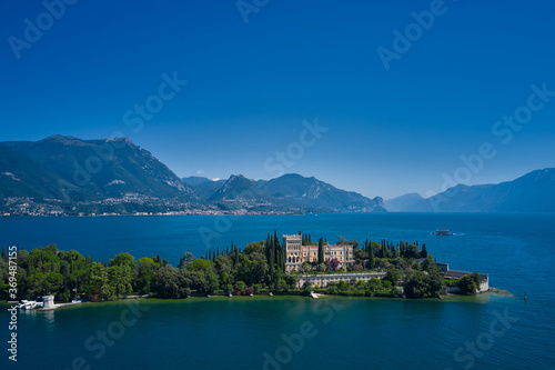 Aerial view of the island Garda, Lake Garda, Italy Aerial photography. In the background Alps, blue sky
