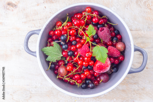 mixed berries in a bowl on wooden table