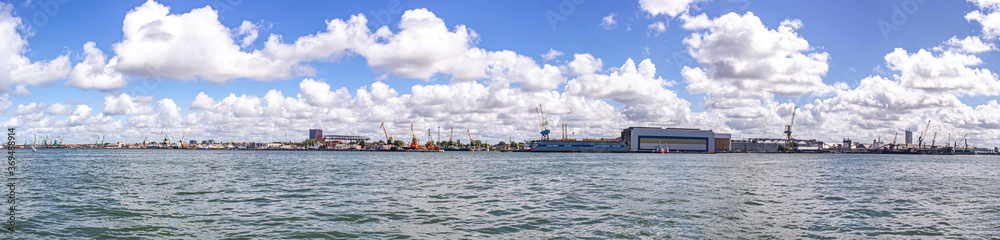 Panorama of heavy harbor jib cranes and ships on the pier in the Klaipeda Sea Port