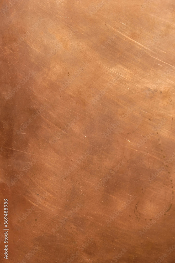 Copper background. Scratched copper surface. Copperplate. Copy space. Minimalism. Vertical image.