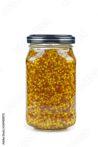 Dijon mustard sauce in glass jar on a white background