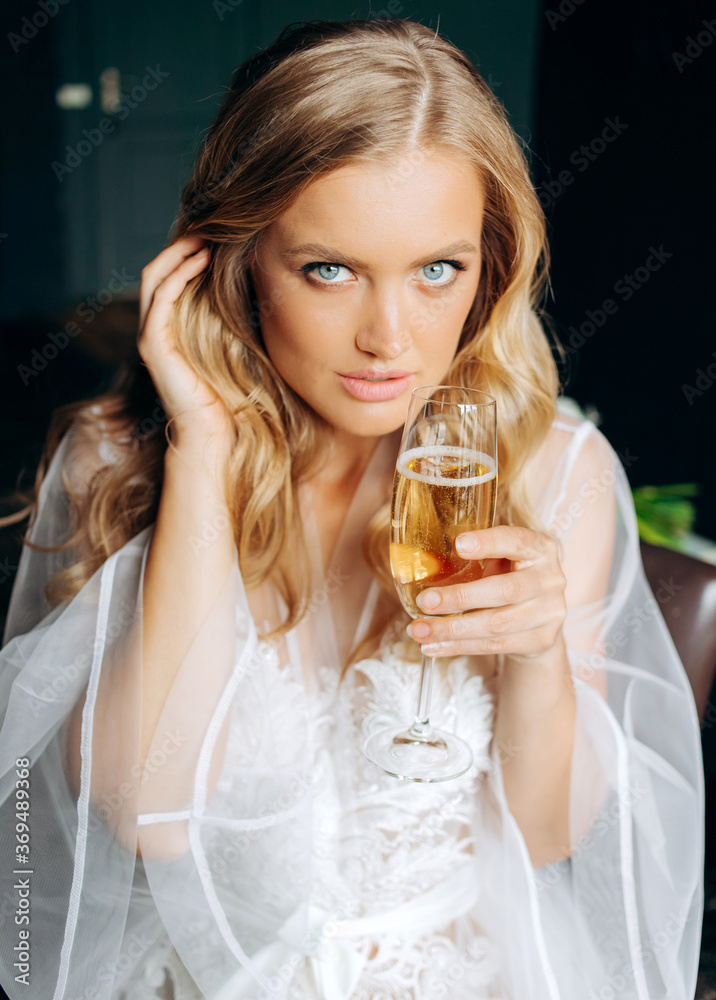 Portrait of a pretty bride holding a glass of champagne in her hand. Boudoir morning. Portrait of a pretty bride holding a glass of champagne in her hand. Boudoir morning.