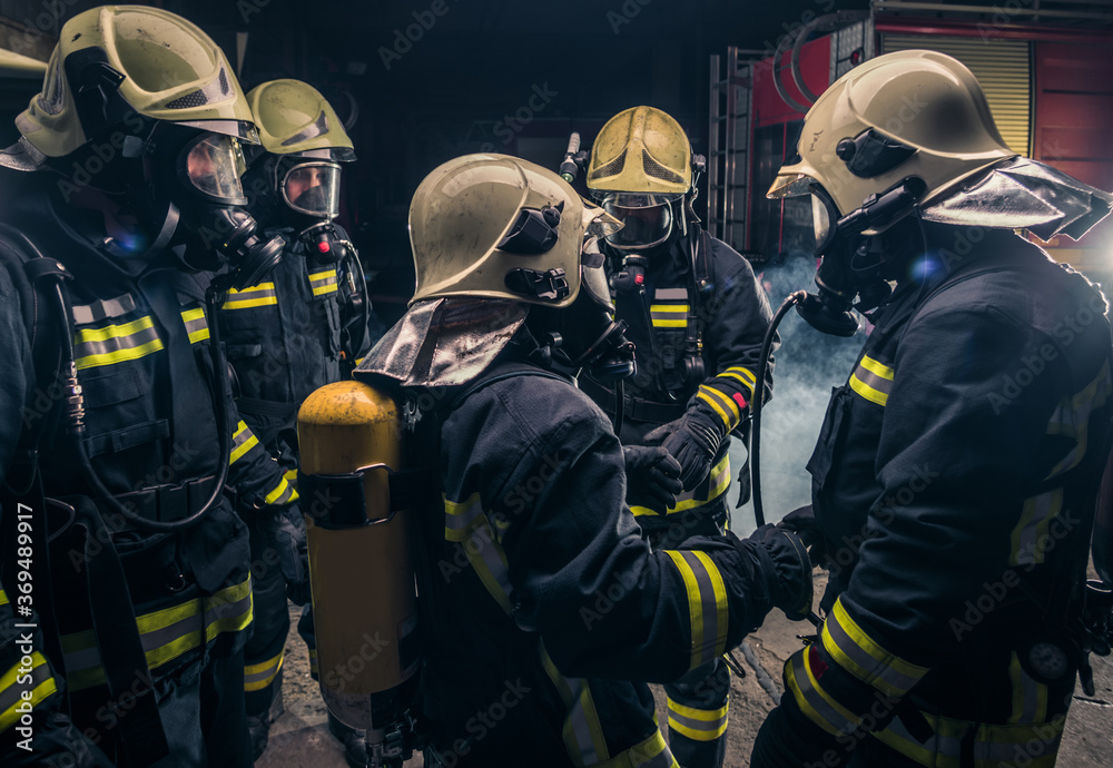 Group of firefighters in the fire department checking their gas mask equipment Group of firefighters in the fire department checking their gas mask equipment