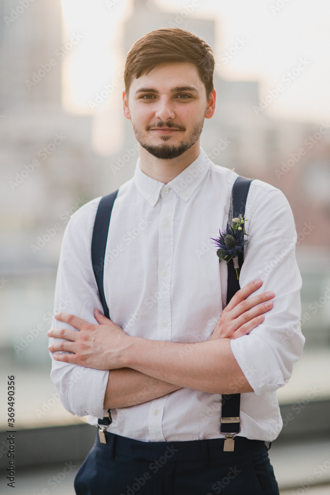 Φωτογραφία Romantic and handsome caucasian man in stylish classic clothes with a boutonniere on his suspenders