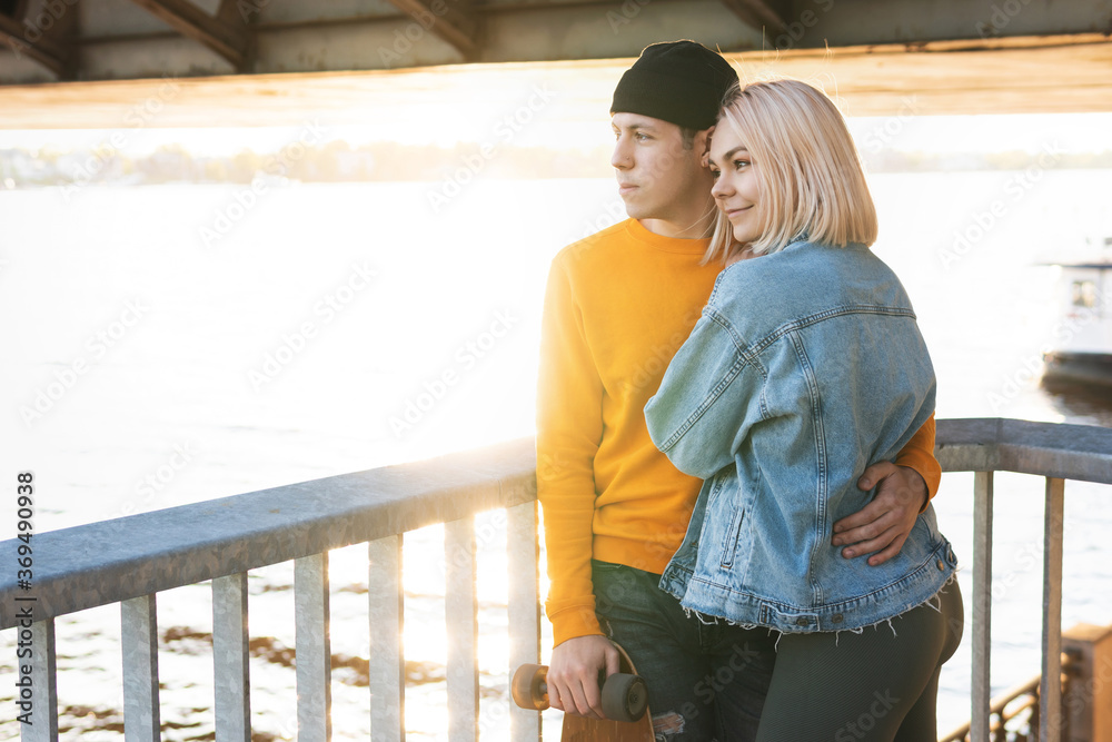 Stylish teenage couple under a bridge at sunset Stylish teenage couple under a bridge at sunset
