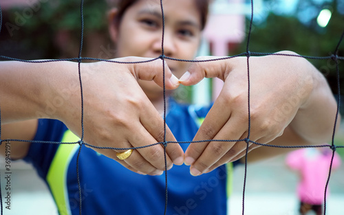 Portrait of a female athlete creating a heart shape by hand .