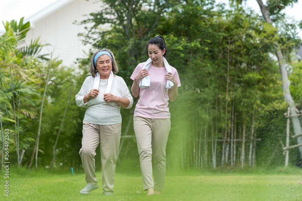 Smile young woman take care hug happy elder after running (cool down) in the morning exercise in the park. Smile young woman take care hug happy elder after running (cool down) in the morning exercise in the park.