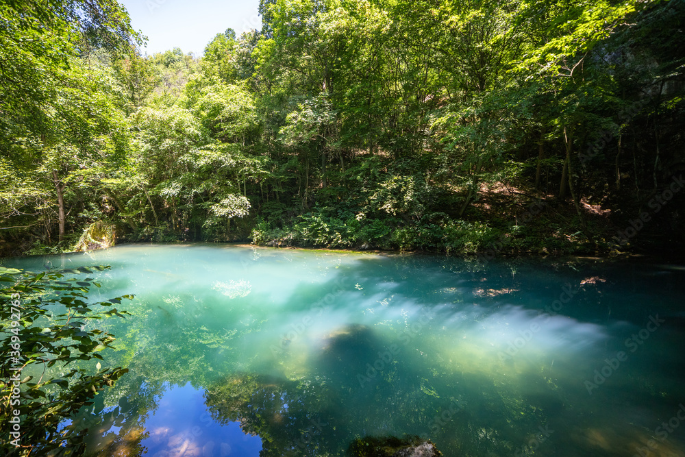 Naklejka premium Krupajsko Vrelo (The Krupaj Springs) in Serbia, beautiful water spring with waterfals and caves. Healing light blue water.