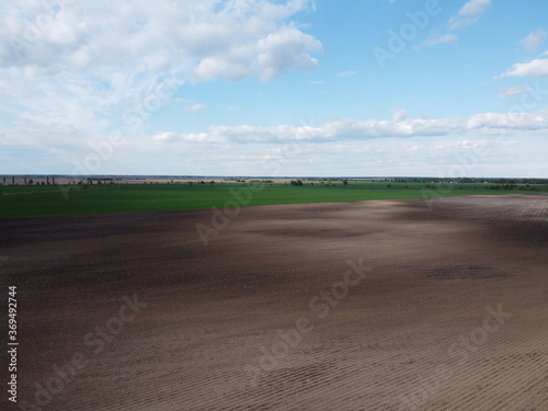 Picturesque farmland, aerial view. Beautiful sky over a plowed field.