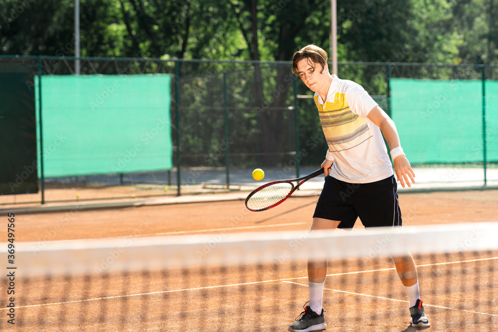 Young tennis player hitting the ball