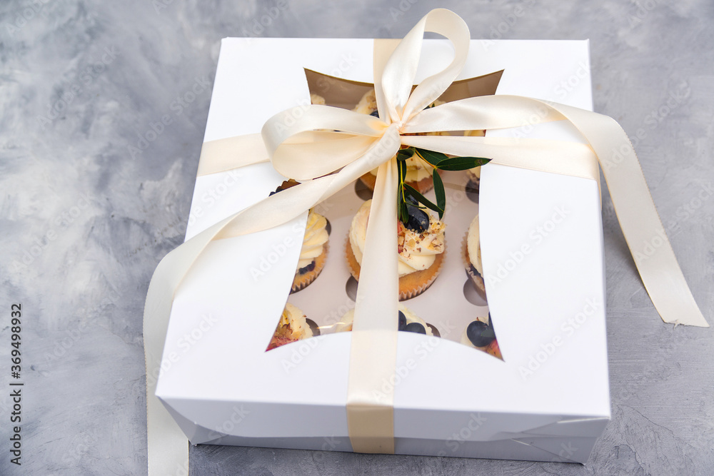 Present box full of fruit cupcakes. Holidays cupcakes with strawberry and blueberry. Cupcake packaging. Delivery. Present box full of fruit cupcakes. Holidays cupcakes with strawberry and blueberry. Cupcake packaging. Delivery.