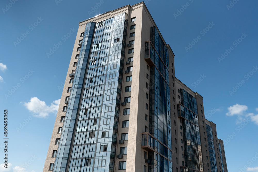 Multi-storey buildings against a blue sky with clouds.