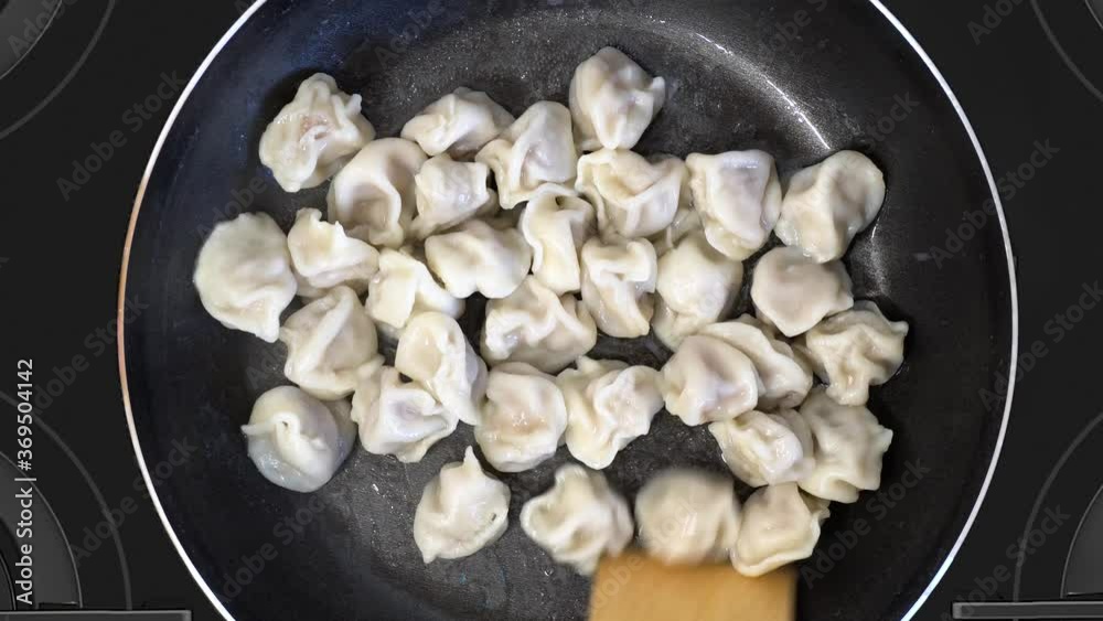 Boiled dumplings are fried in a hot pan. Boiled dumplings are fried in a hot pan.