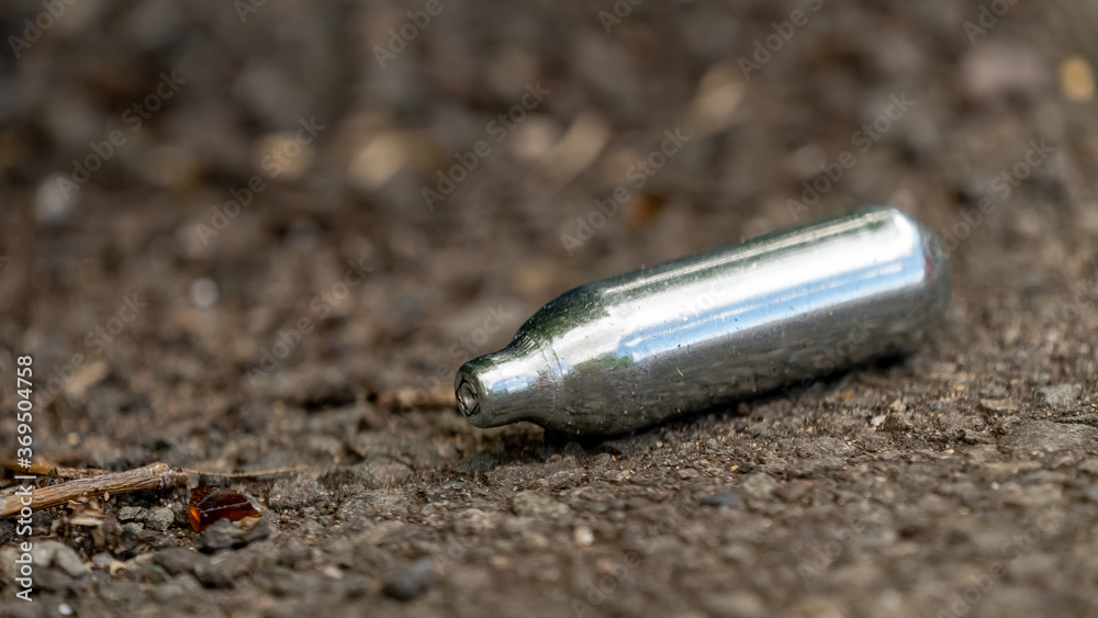 Close-up of a discarded Nitrous oxide gas canister Close-up of a discarded Nitrous oxide gas canister