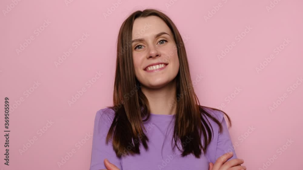 Cheerful happy young woman turning crossed hands and looking at camera with toothy smile, cute brunette girl expressing confidence optimism, positive emotions, isolated on pink studio background Cheerful happy young woman turning crossed hands and looking at camera with toothy smile, cute brunette girl expressing confidence optimism, positive emotions, isolated on pink studio background