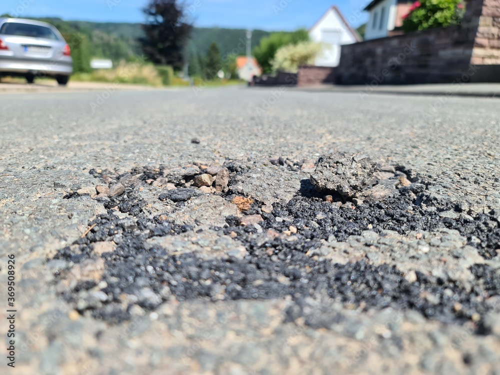 Schäden auf einer Strasse mit losen Asphalt Schäden auf einer Strasse mit losen Asphalt