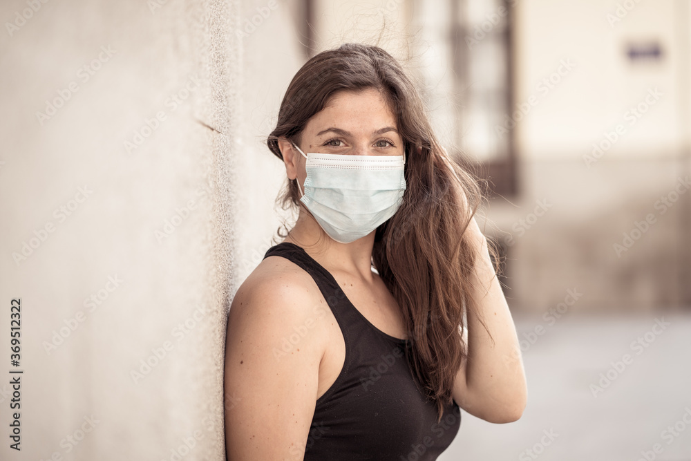 Portrait of attractive young happy woman with protective surgical face mask in public spaces Portrait of attractive young happy woman with protective surgical face mask in public spaces