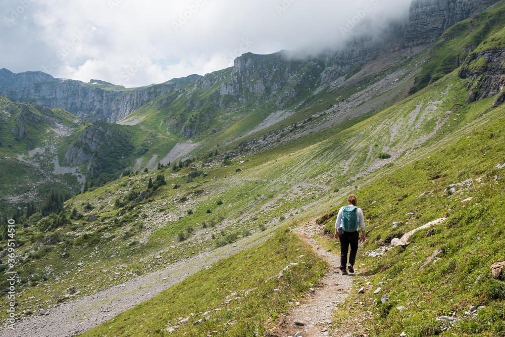 Woman with backpack, hiking in the swiss alps canton of Glarus, Switzerland