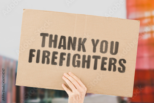 Φωτογραφία The phrase  Thank you firefighters  on a banner in men's hand with blurred background