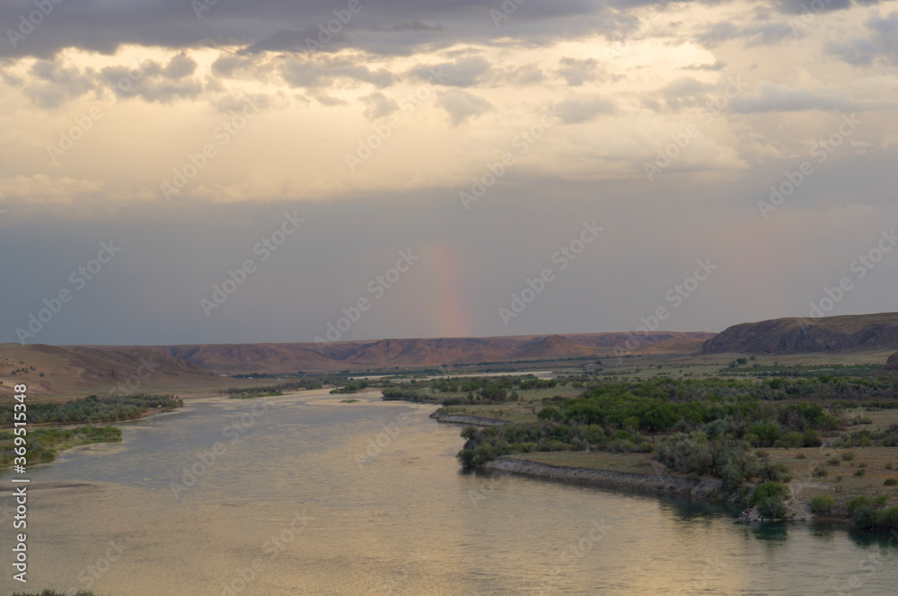 River valley in Kazakhstan. Beautiful river and rainbow in the sky after rain.