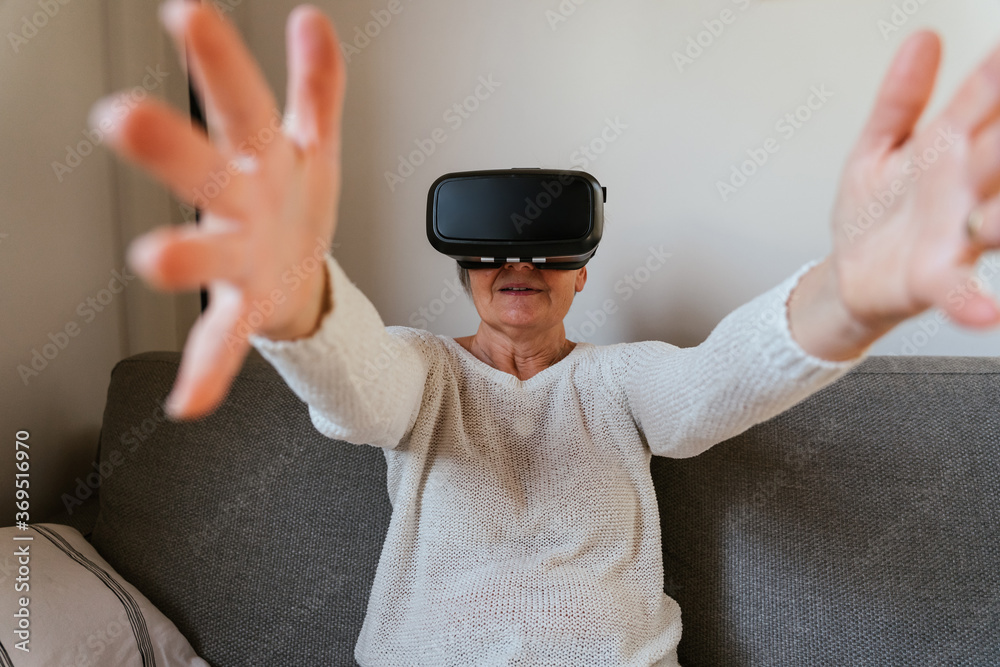 Φωτογραφία Adult woman at home on sofa having fun with vr glasses for advanced realty heads
