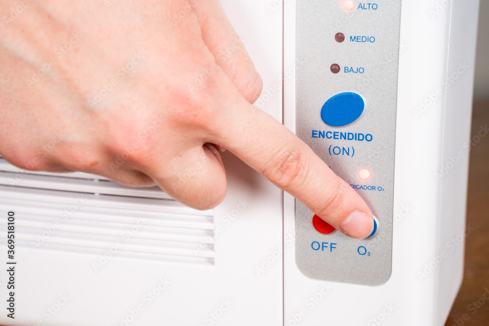 Hand turning on ozone machine generators to cleaning and disinfection during covid 19 epidemic. Details in Spanish. Hand turning on ozone machine generators to cleaning and disinfection during covid 19 epidemic. Details in Spanish.