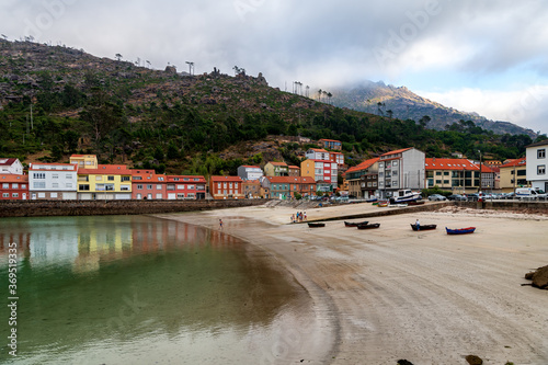 View of the beach and colorful village of O Pindo in Galicia, northwestern Spain.
