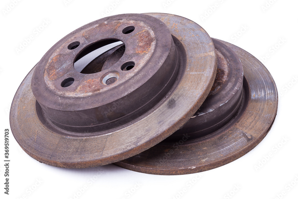 Pair of old brake discs covered with rust on a white isolated background in a photography studio. Seasonal repair of suspension and brake system in workshop or sale of spare parts for auto analysis. Pair of old brake discs covered with rust on a white isolated background in a photography studio. Seasonal repair of suspension and brake system in workshop or sale of spare parts for auto analysis.