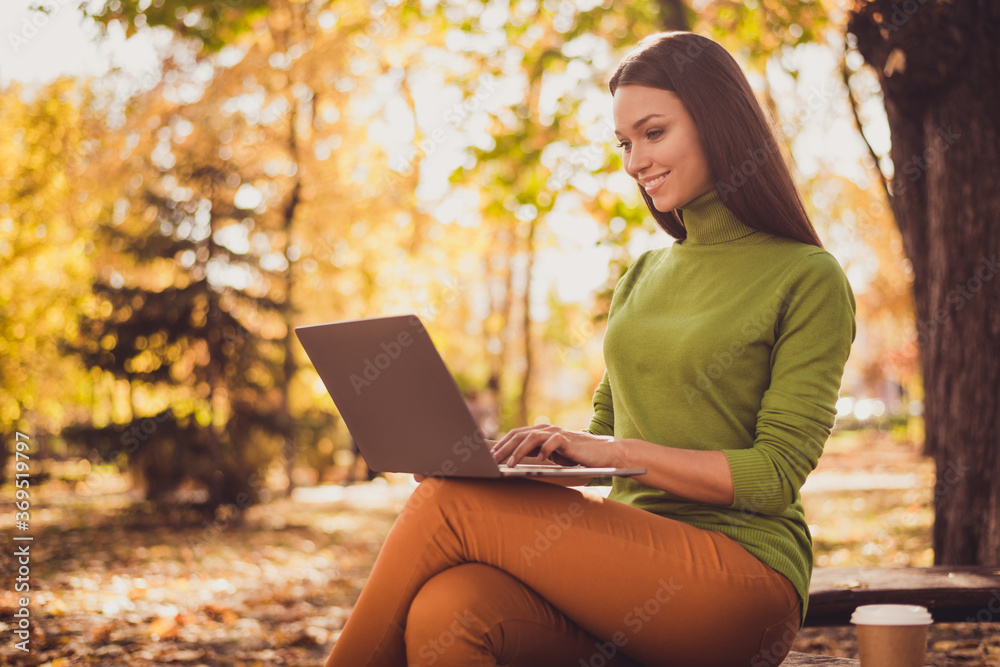 Photo of pretty cute lady smiling sit bench park hold laptop drink coffee remotely work project programming app communicate chatting client wear green turtleneck orange pants outdoors Photo of pretty cute lady smiling sit bench park hold laptop drink coffee remotely work project programming app communicate chatting client wear green turtleneck orange pants outdoors