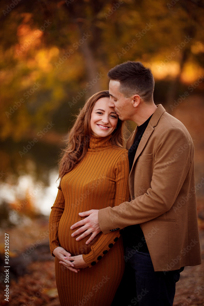 pregnant with husband in autumn Park by river. pregnant with husband in autumn Park by river.