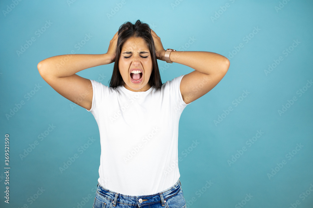 Young beautiful woman crazy and scared with hands on head, afraid and surprised of shock with open mouth Young beautiful woman crazy and scared with hands on head, afraid and surprised of shock with open mouth