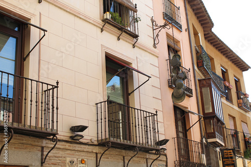  Facades of traditional buildings with old pans hanging from wall, in Toledo.