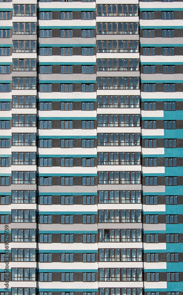 Facade of a house in turquoise and white with brown window frames Facade of a house in turquoise and white with brown window frames